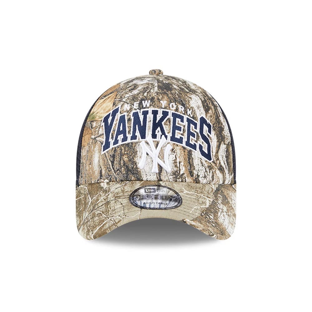 New York Yankees MLB Realtree Camo Navy New Era 9FORTY A-Frame Trucker Adjustable Cap, front view showing the raised navy Yankees lettering and white NY logo on a camo-patterned crown with a 9FORTY size sticker on the curved visor.