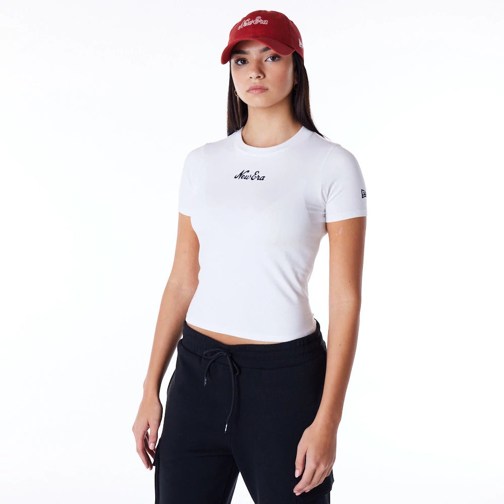 New Era Womens White Slim T-Shirt, on-model view showing the fitted white t-shirt with a black embroidered New Era logo in the centre of the chest and a smaller embroidered logo on the sleeve, worn with a red cap featuring a raised white logo.