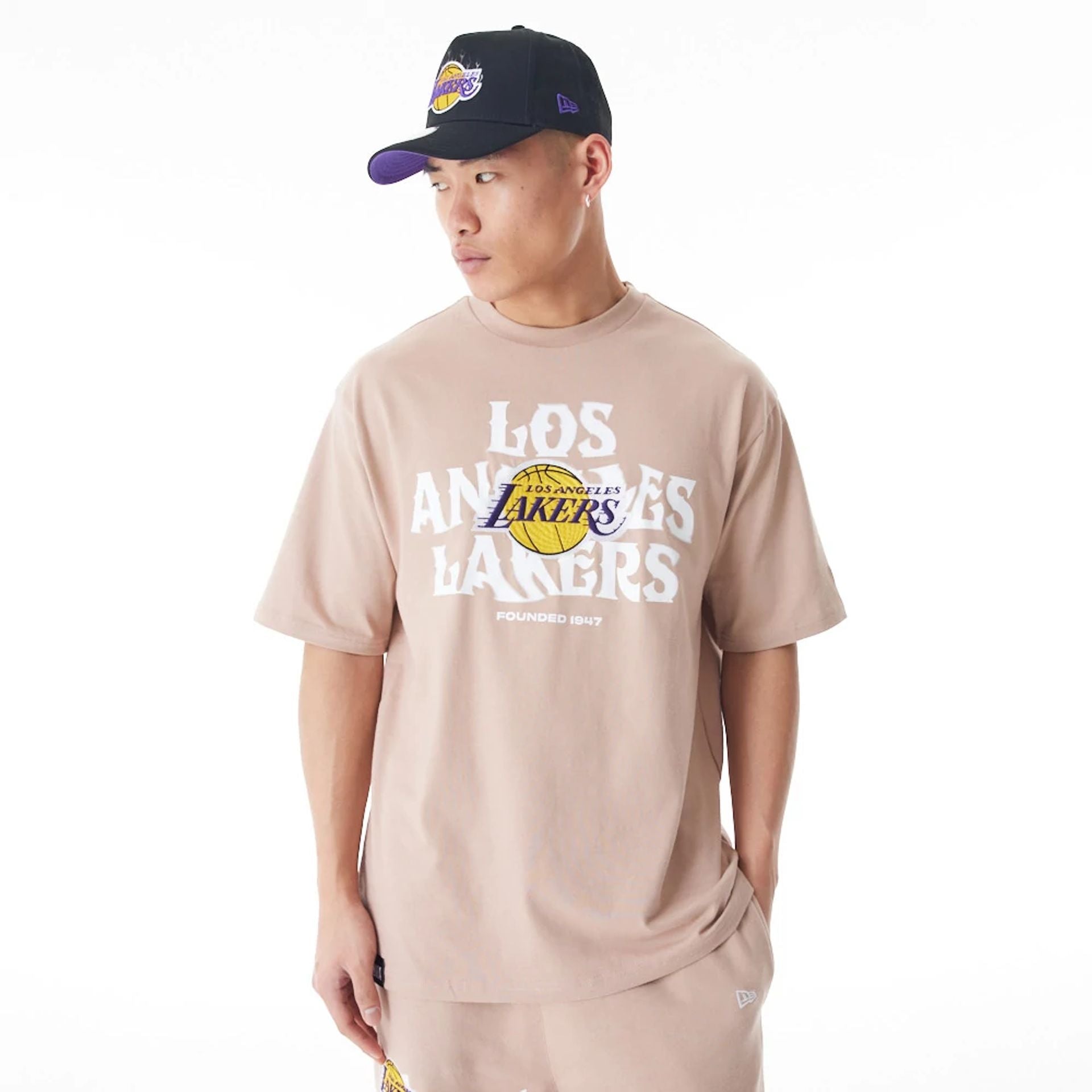 The Male model is wearing LA Lakers NBA Graphic Beige Oversized T-Shirt 1