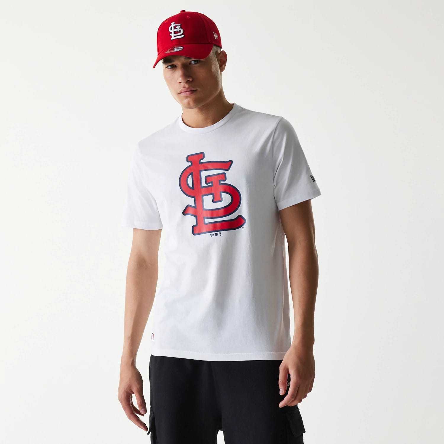 New Era St. Louis Cardinals MLB Regular White T-Shirt, on-model view showing the white shirt with a large red and navy outlined logo on the front, paired with a red cap featuring an embroidered white logo on the front panel.