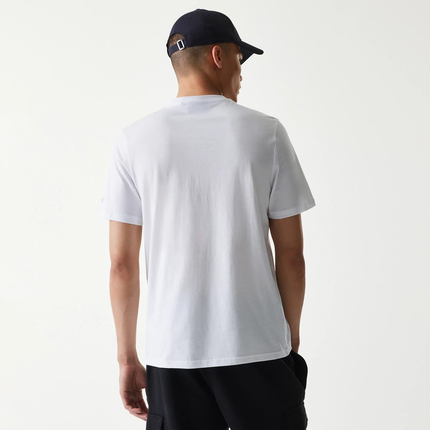New Era MLB Generic Logo MLB Regular White T-Shirt, rear view showing the plain white back with short sleeves, on a model wearing a black cap with a debossed logo and metal buckle at the back.