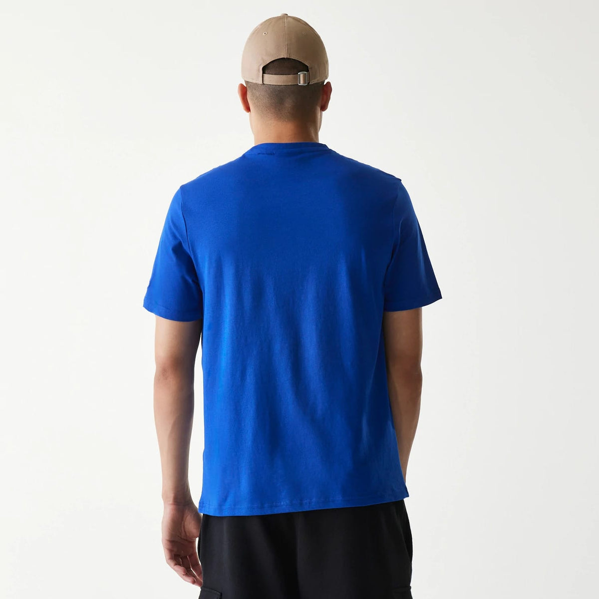 New Era Kansas City Royals MLB Regular Blue T-Shirt, rear view showing the plain blue fabric with short sleeves on a model wearing a beige cap, the back panel extends smoothly without any logos or embellishments.
