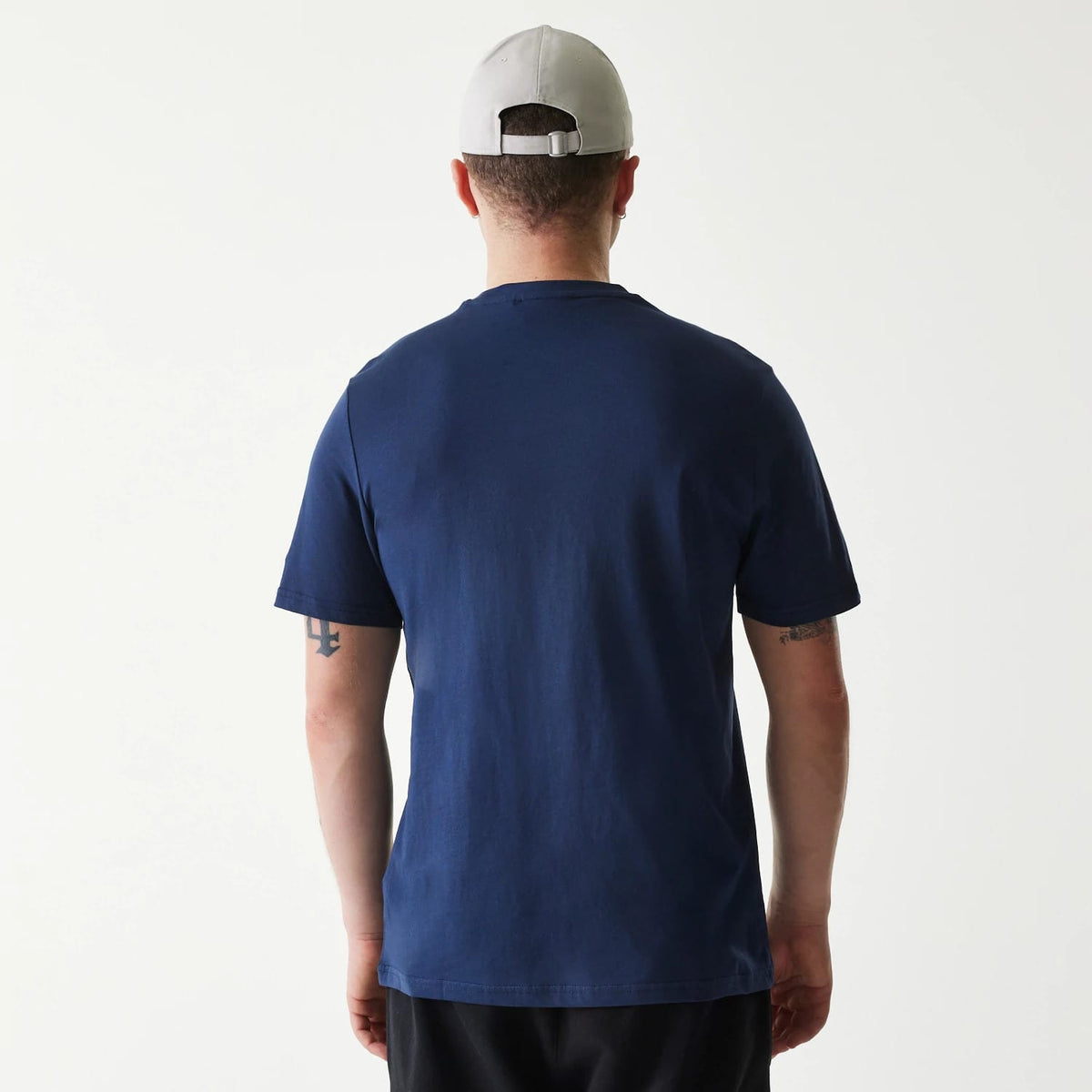 New Era Houston Astros MLB Regular Dark Blue T-Shirt, rear view showing the solid dark blue colour across the back with short sleeves, worn by a model wearing a light grey cap with an adjustable strap at the back.