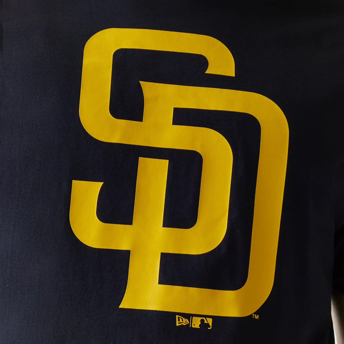 New Era San Diego Padres MLB Regular Navy T-Shirt, front view showing a large yellow interlocking SD logo centred on the chest, above a small printed New Era logo and MLB batterman logo at the bottom.