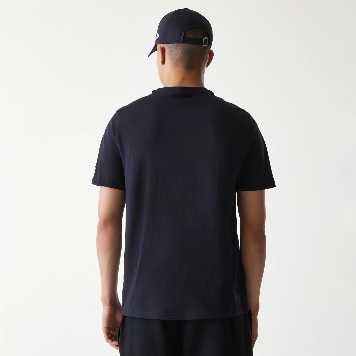 New Era San Diego Padres MLB Regular Navy T-Shirt, rear view showing the plain navy back with short sleeves, worn by a model wearing a navy cap featuring a small raised logo on the side.
