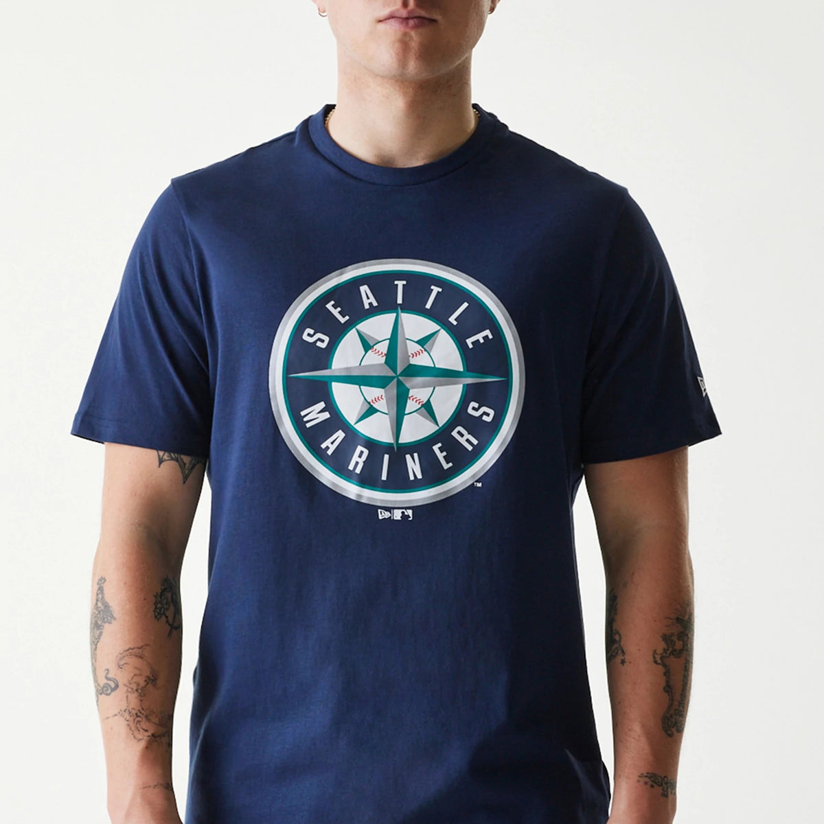 New Era Seattle Mariners MLB Regular Dark Blue T-Shirt, on-model view showing the large round team logo centred on the chest featuring compass rose and text, New Era logo in white on the left sleeve.