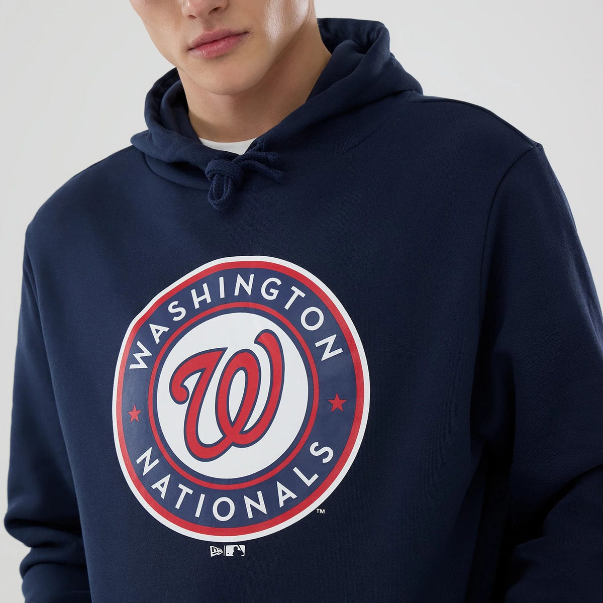 New Era Washington Nationals MLB Dark Blue Pullover Hoodie, front view showing the large circular team logo with a red W in the centre, surrounded by Washington Nationals text, positioned boldly on the chest of the dark blue fabric.