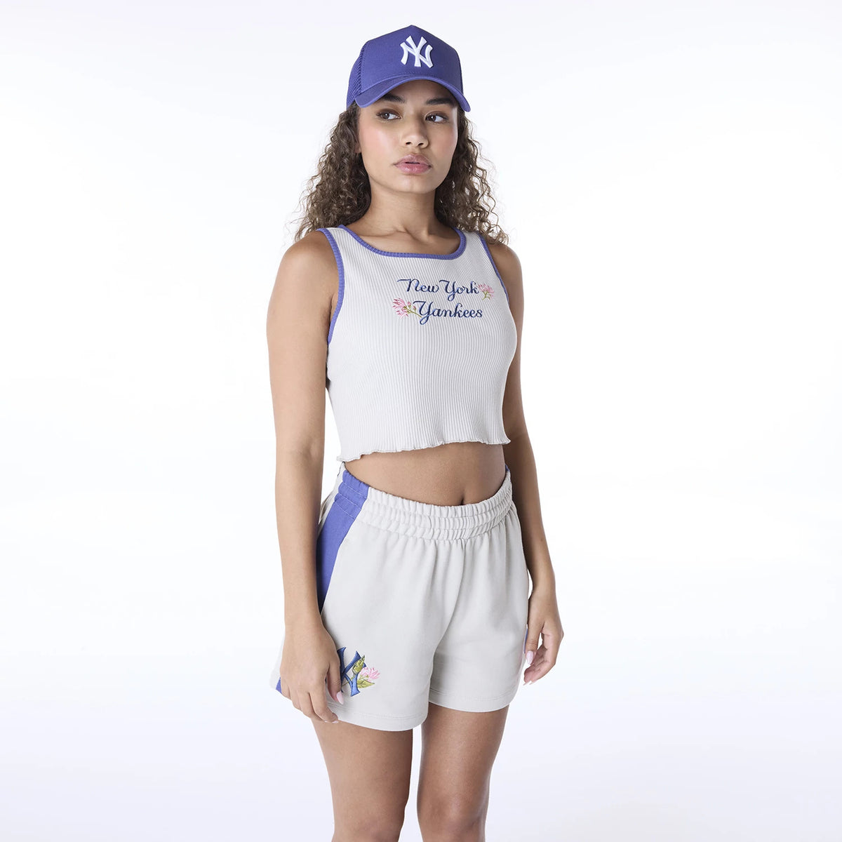 New Era New York Yankees Womens MLB Floral Cream Vest, on-model view with an embroidered New York Yankees logo and floral design on the cream vest, styled with matching shorts and a blue cap featuring a white team logo.