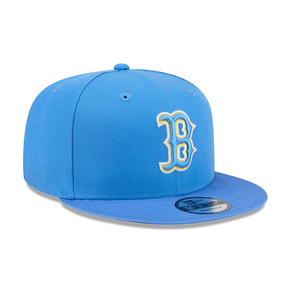 Boston Red Sox MLB Evergreen Blue New Era 9FIFTY Snapback Adjustable Cap, front view with a raised yellow-edged white B logo on the front panel, blue visor, and a 9FIFTY size sticker on top of the visor.