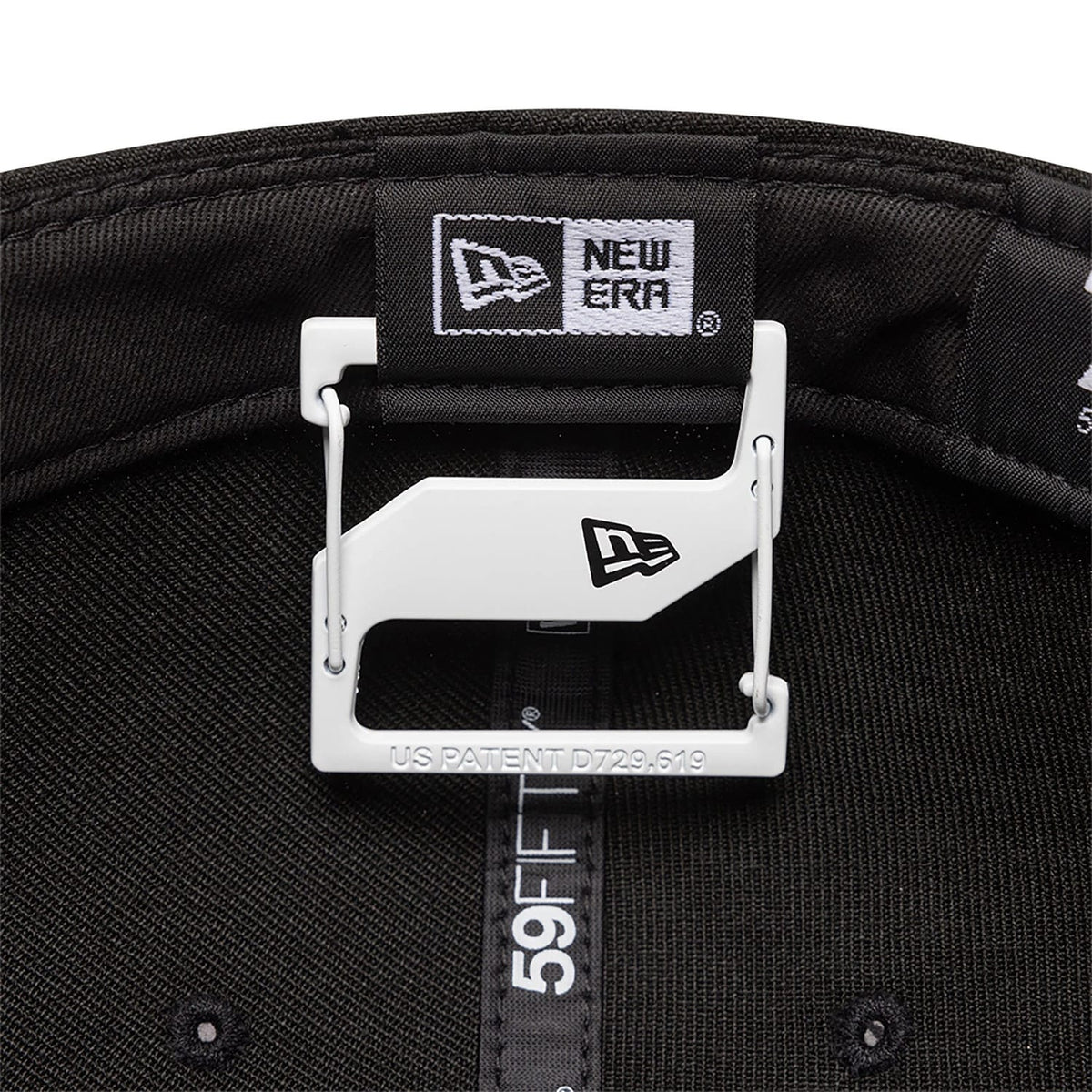 New Era White Cap Clip, inside view with the clip attached to the black taping of a 59FIFTY cap, displaying the New Era flag logo on the white clip and the inner branded taping with black stitching.