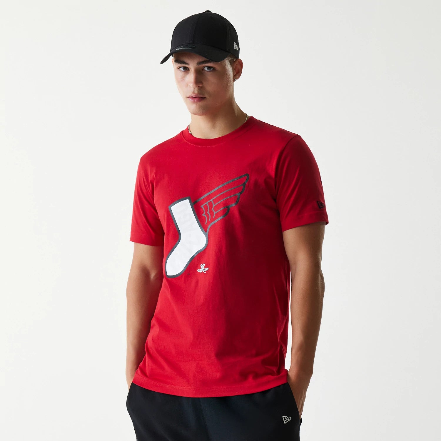 New Era Chicago White Sox MLB City Connect 2025 Red T-Shirt, on-model view showing a red tee with a winged white sock graphic on the front, and a small debossed New Era logo on the sleeve.