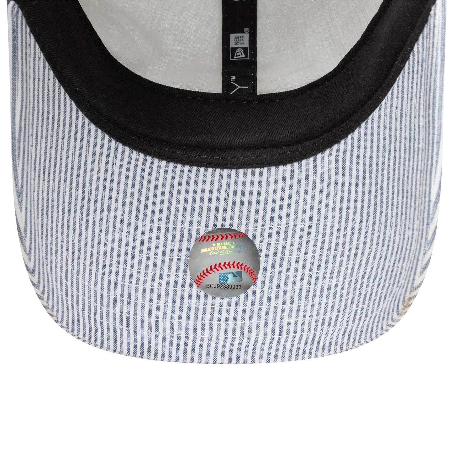 New York Yankees MLB Seersucker Navy New Era 9TWENTY Adjustable Cap, inside view showing the black inner sweatband, white taping, and a white and navy striped undervisor with an MLB holographic sticker adhered to the surface.