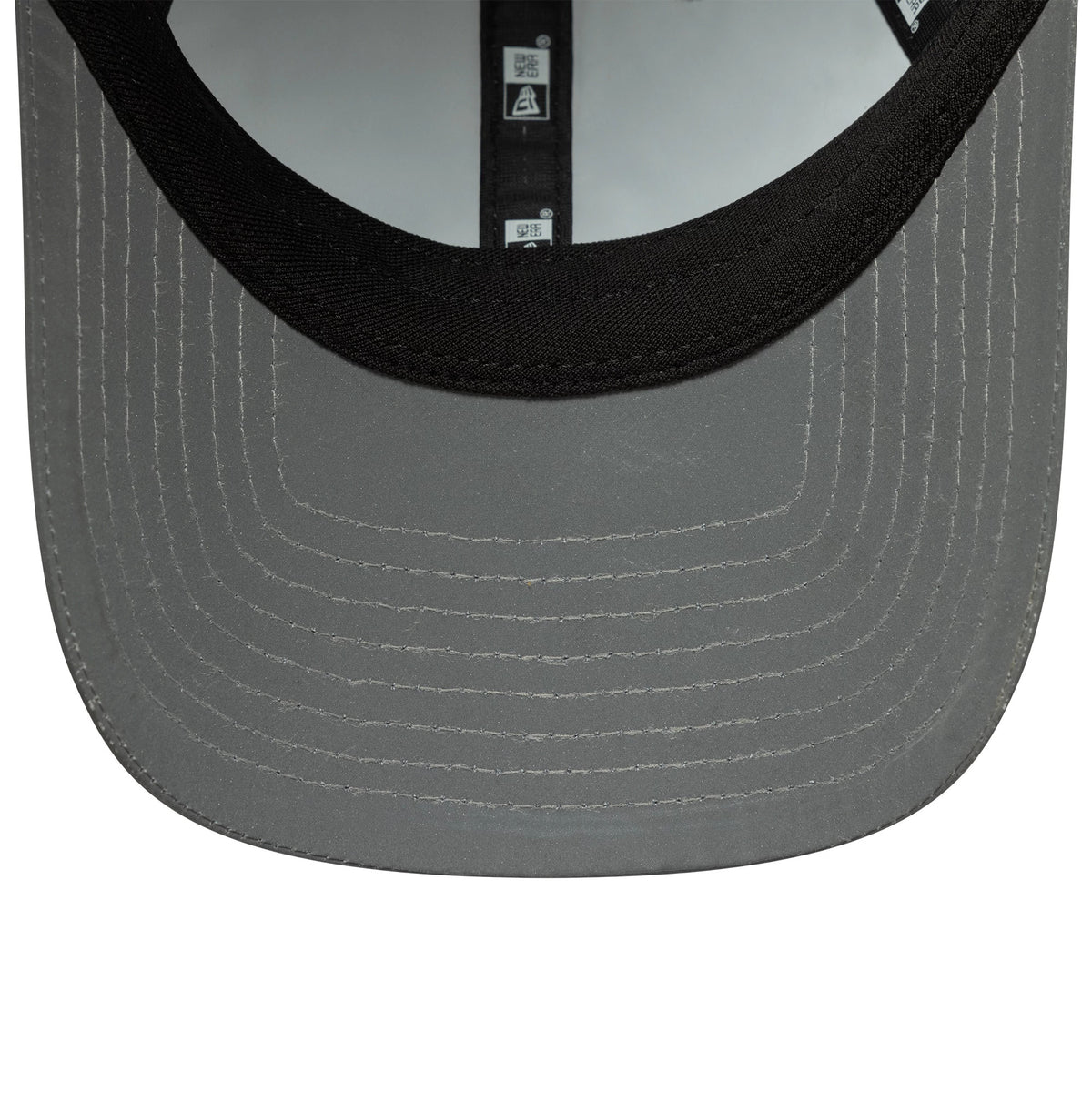 Womens New Era Recycled Reflective Silver Pony Tail Adjustable Cap, inside view showing grey undervisor and black sweatband with branded taping lining the crown, highlighting intricate stitching on the visor.