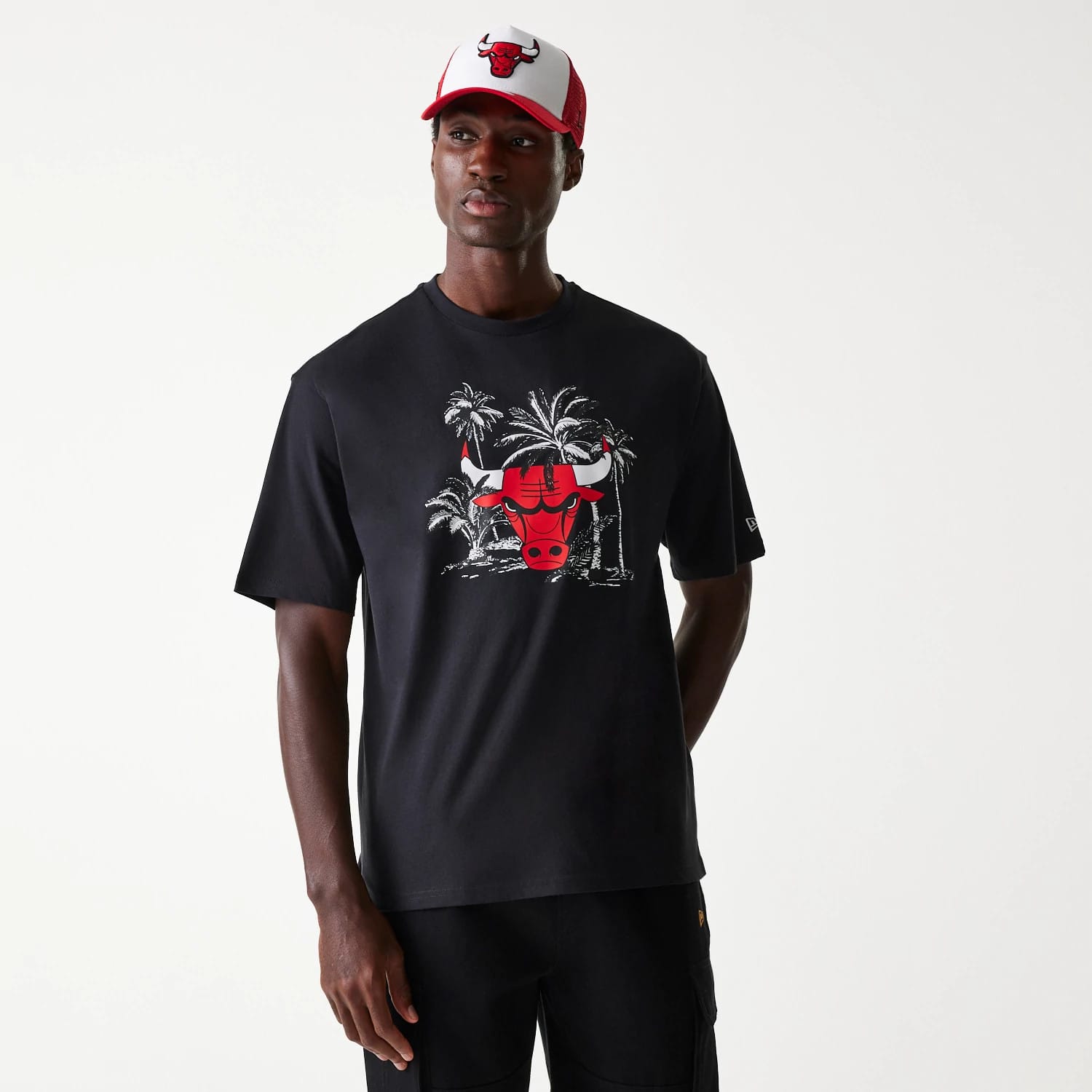 New Era Chicago Bulls NBA Palm Tree Black Oversized T-Shirt, on-model view showing front design with red bull logo against white palm trees, short sleeves, and a New Era logo debossed on the left sleeve.