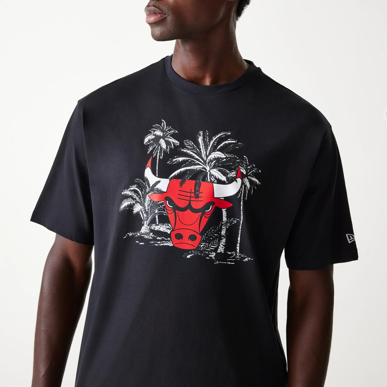 New Era Chicago Bulls NBA Palm Tree Black Oversized T-Shirt, front view showing a large red Bulls logo with palm tree graphics on the chest and a small embossed New Era logo on the left sleeve.