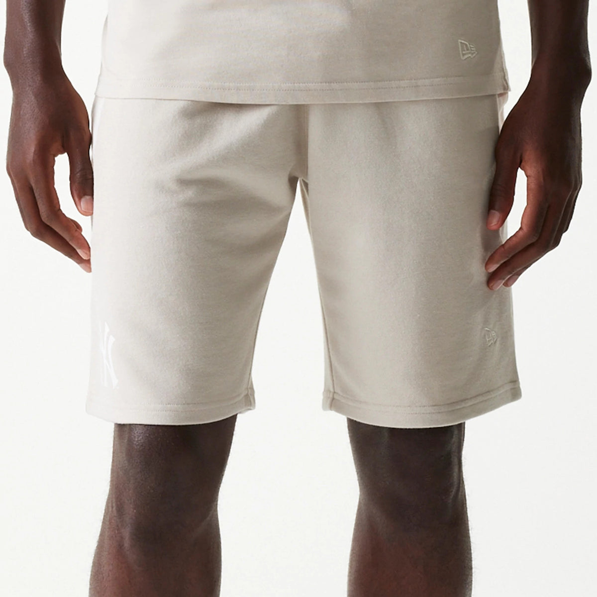 New Era New York Yankees MLB Raglan Cream Shorts, front view showing the cream fabric with a raised New York Yankees logo on the left leg and a raised New Era logo near the right hem.