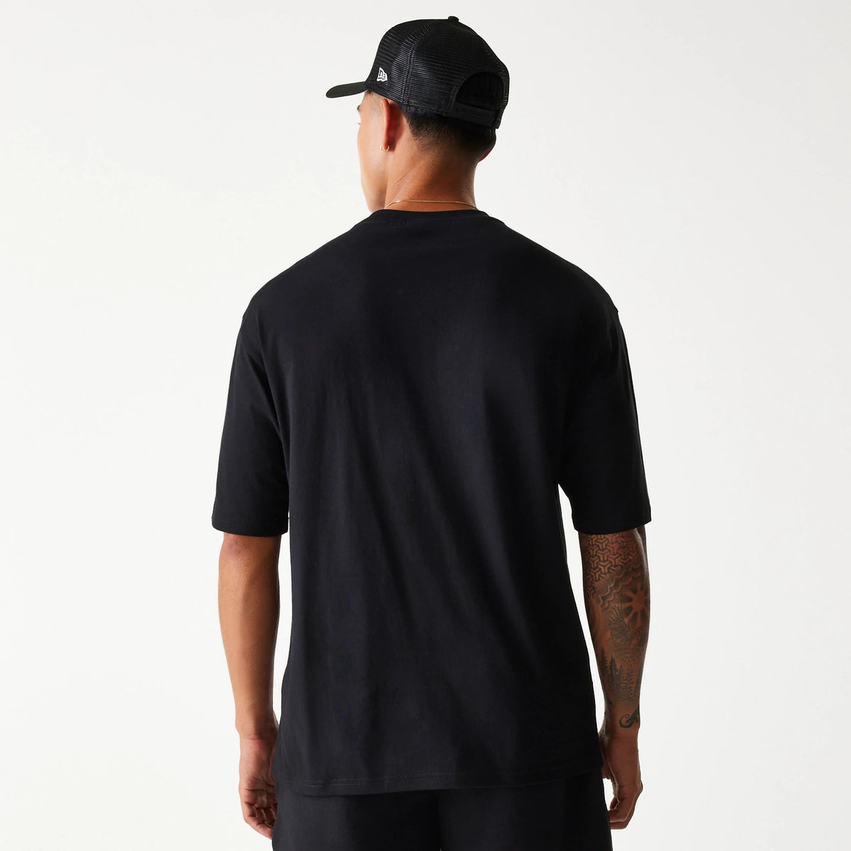 New Era Chicago Bulls NBA Team Graphic Black Oversized T-Shirt, rear view showing the plain black back of the oversized T-shirt worn by a person, emphasizing the relaxed fit with short sleeves and straight hem.