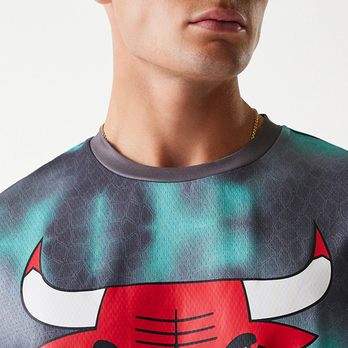 New Era Chicago Bulls NBA All Over Print Green Oversized T-Shirt, front view showing the large red Bulls logo prominently across the chest, set on a green background with dark abstract patterns and a grey round neck collar.