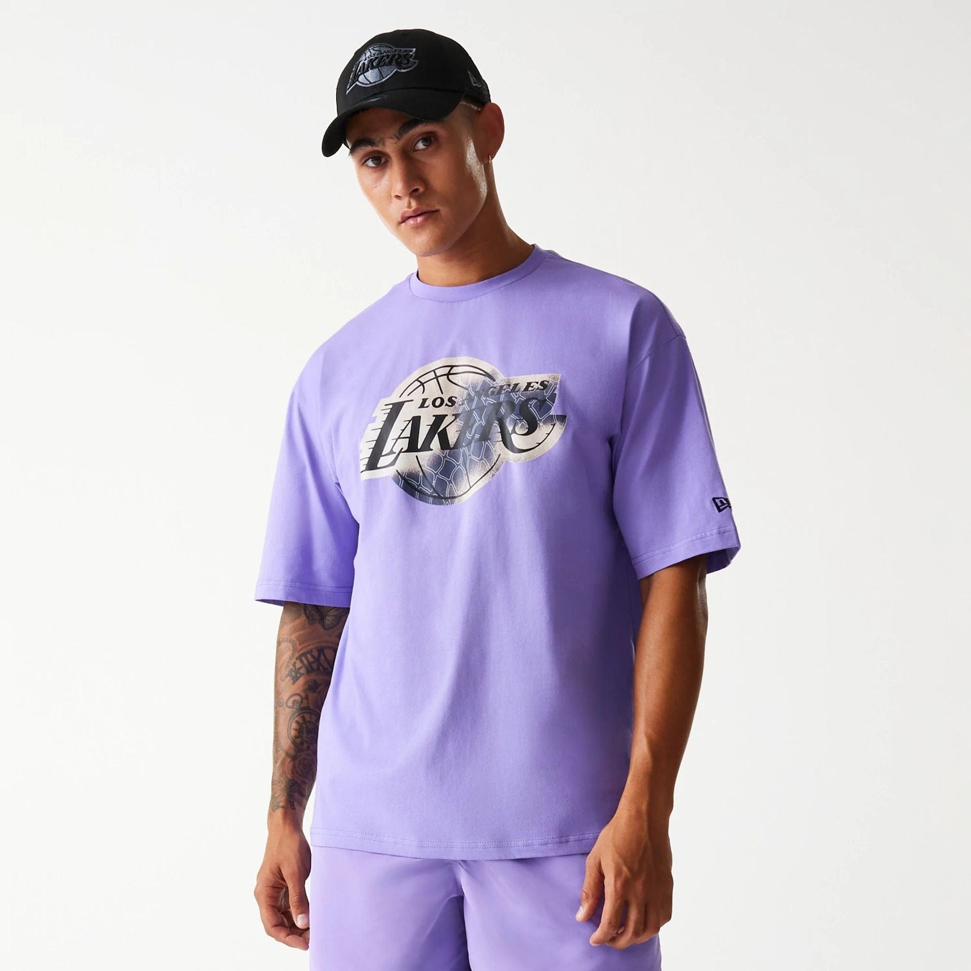 The Male model is wearing LA Lakers NBA All Over Print Infill Purple Oversized T-Shirt 1