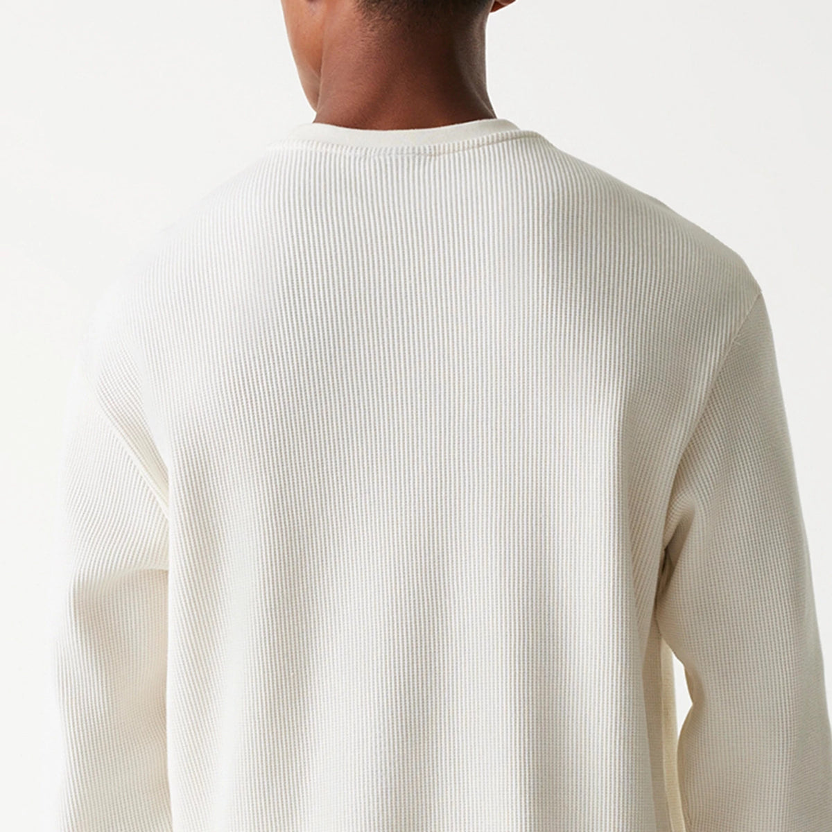 New Era Waffle Open White Oversized Crew Neck Sweater, back view on a model highlighting the textured waffle knit design across the shoulders and upper back, with a relaxed fit and simple crew neck.
