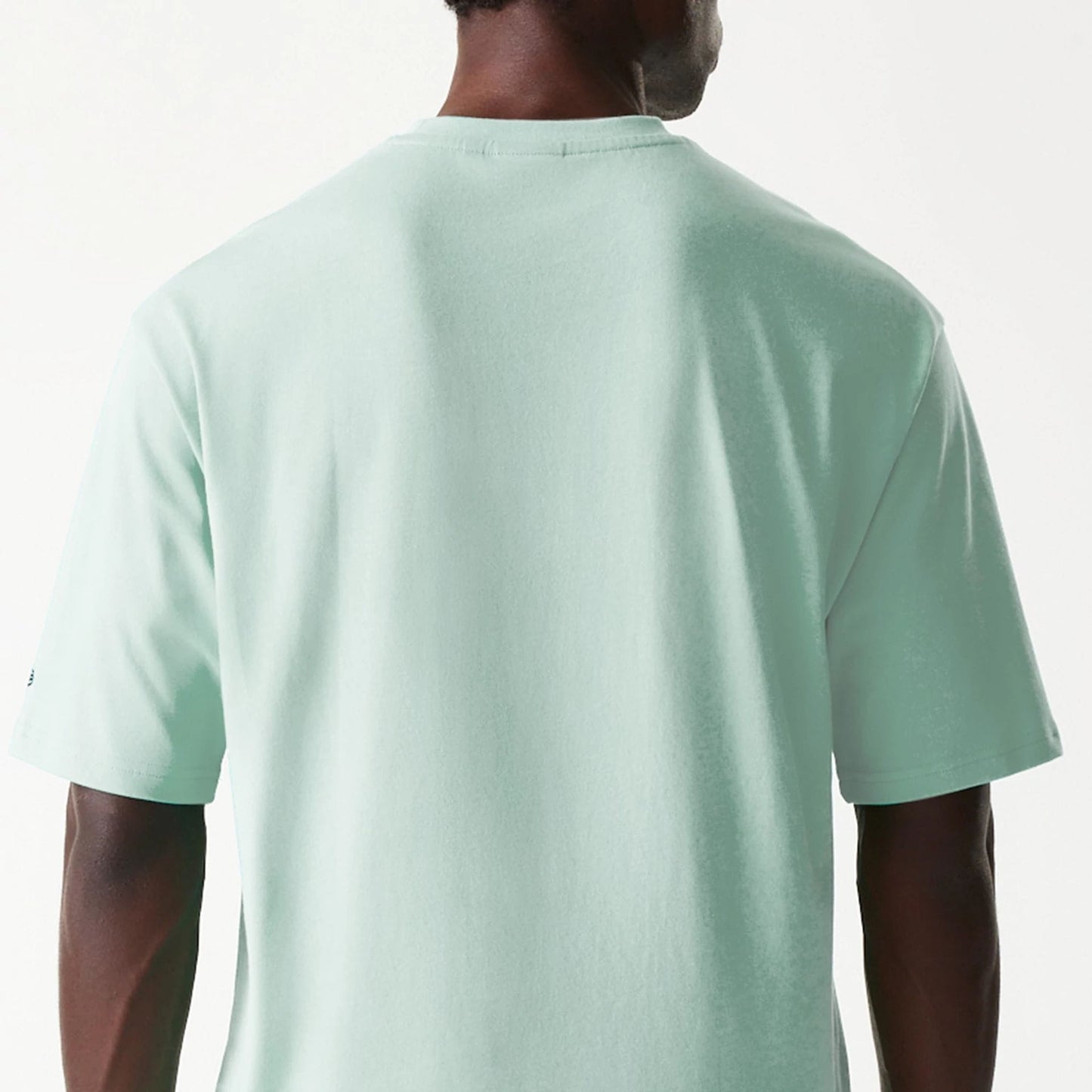 The Male model is wearing New Era Outdoor Graphic Pastel Green Oversized T-Shirt 7