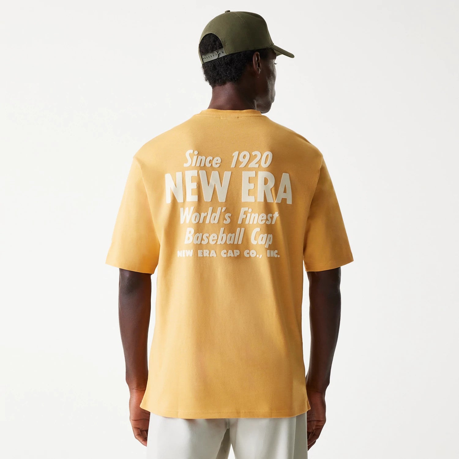 The Male model is wearing New Era Graphic Beige Oversized T-Shirt 2