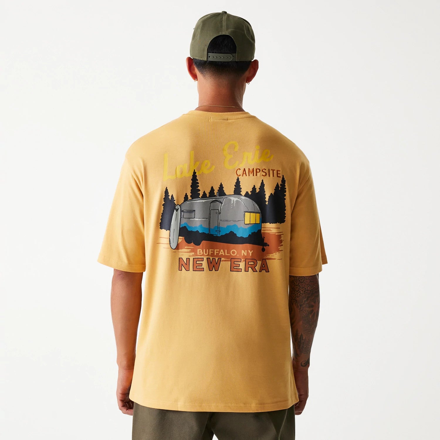 New Era Vacation Graphic Beige Oversized T-Shirt, rear view showing a colourful campsite graphic with trees and a caravan, the words Lake Erie Campsite in yellow above Buffalo, NY and NEW ERA in red near the bottom.