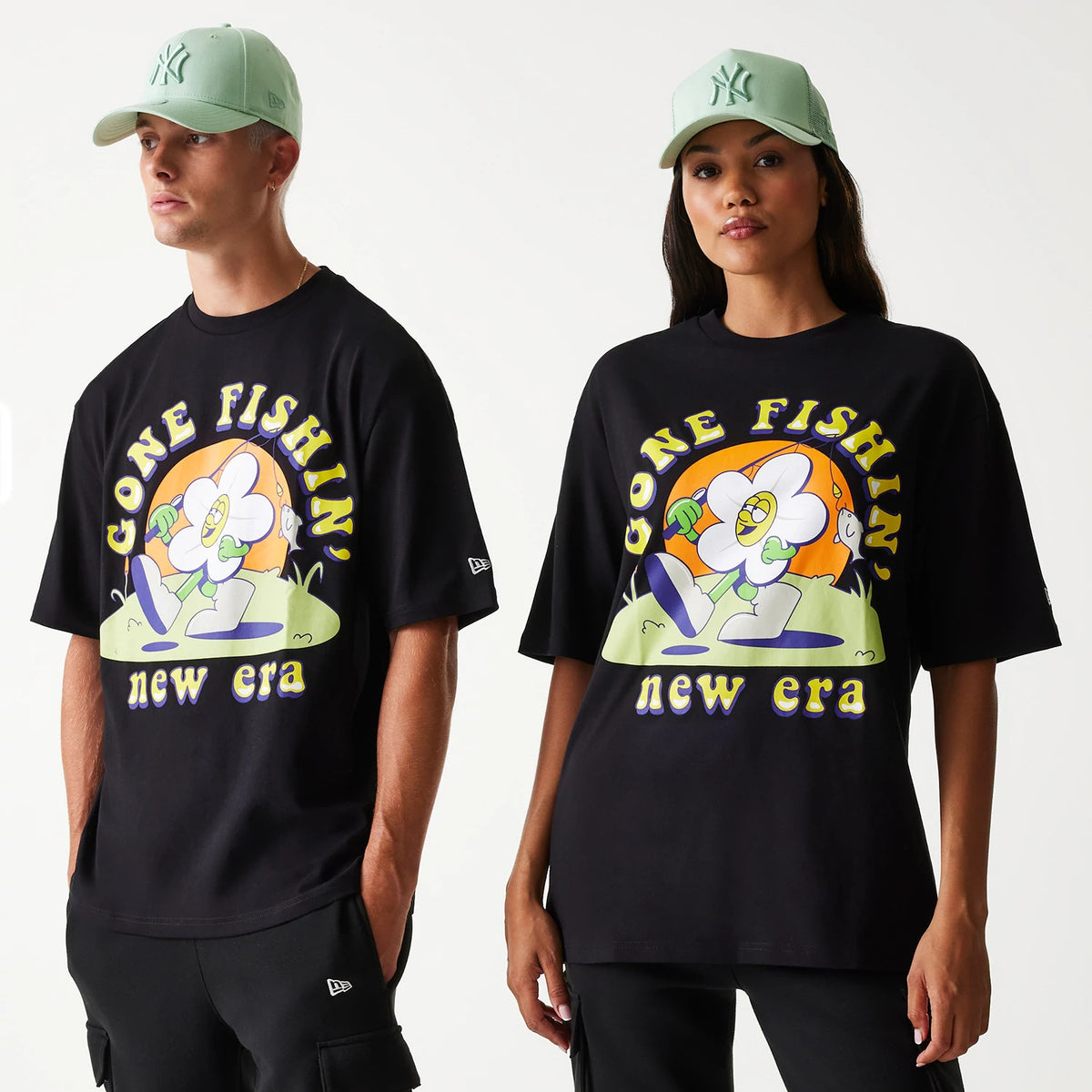 New Era Outdoor Graphic Black Oversized T-Shirt, on-model view showing a large colourful graphic of a flower with Gone Fishin' and new era text, with a debossed New Era logo on the left sleeve above the hem.