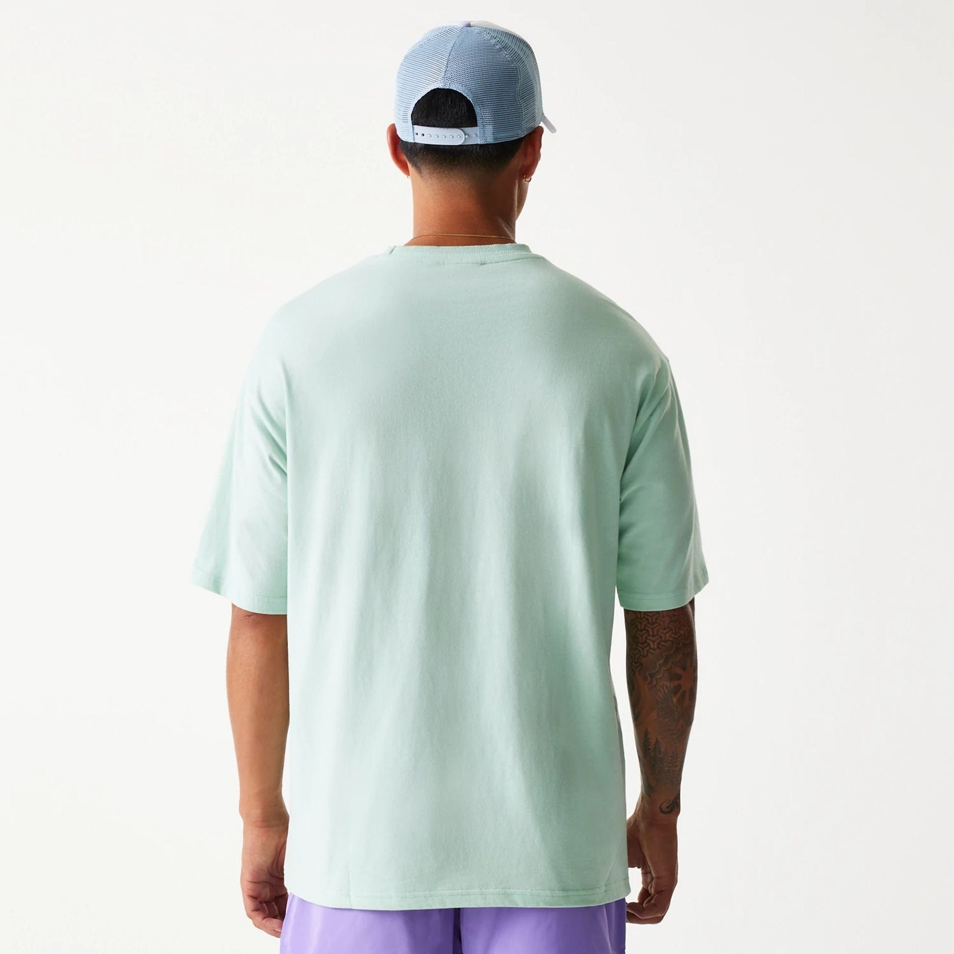 The Male model is wearing New Era Crest Pastel Green Oversized T-Shirt 2