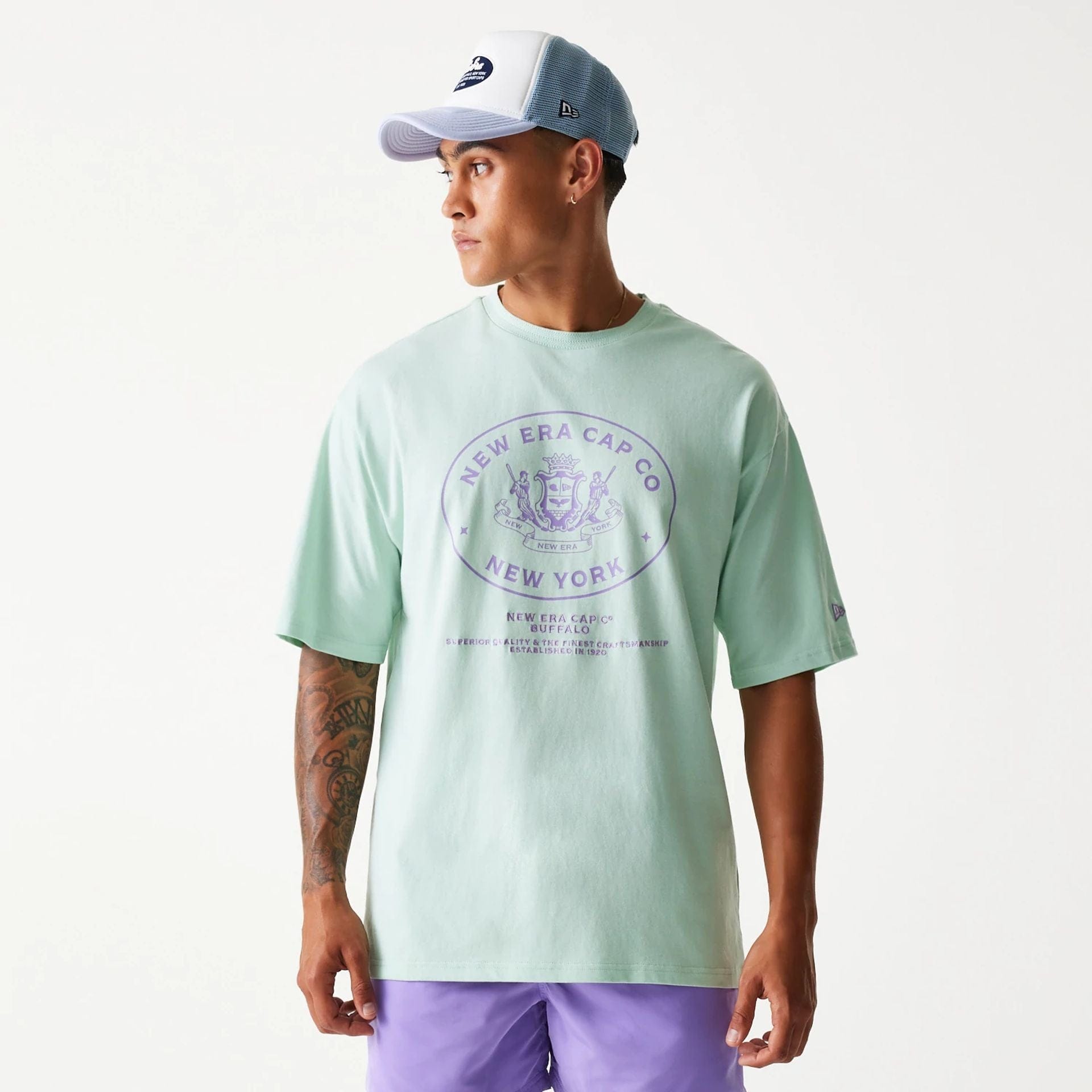 The Male model is wearing New Era Crest Pastel Green Oversized T-Shirt 1