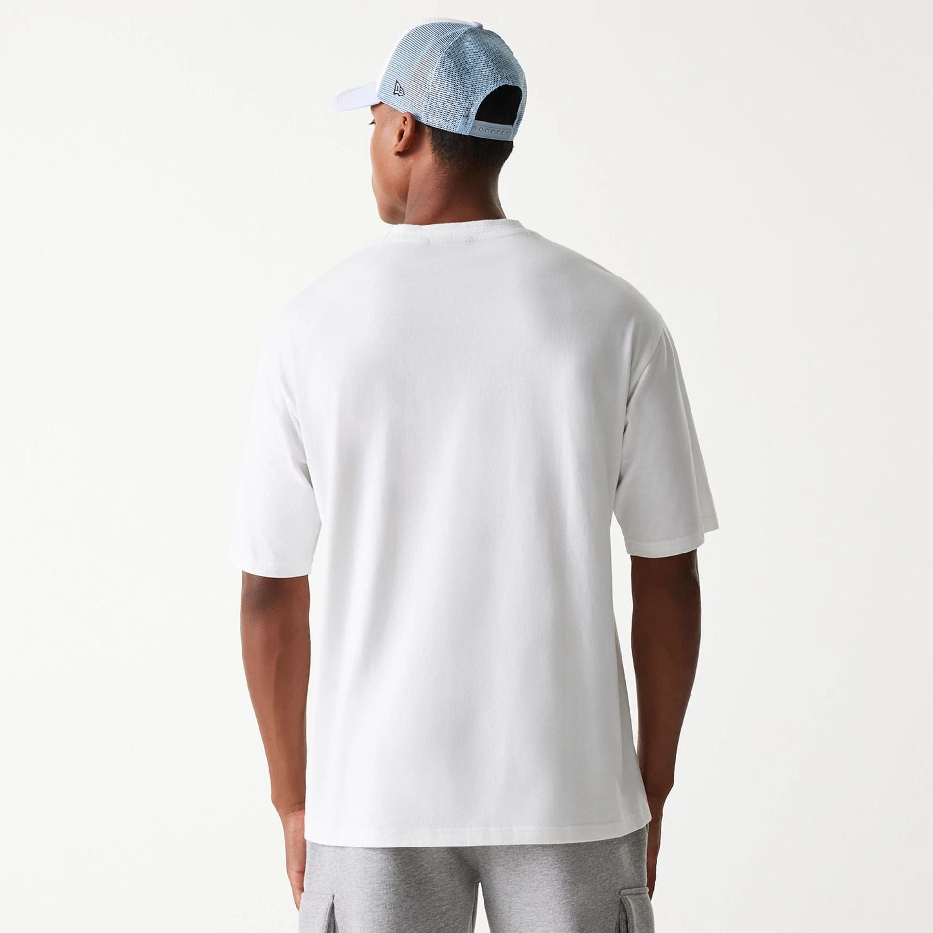 The Male model is wearing New Era Crest White Oversized T-Shirt 2