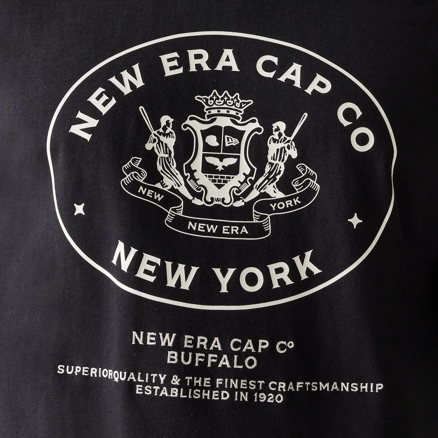 New Era Crest Black Oversized T-Shirt, front view showing a large white crest logo with intricate details including two figures and the words New Era Cap Co New York prominently displayed on the chest.