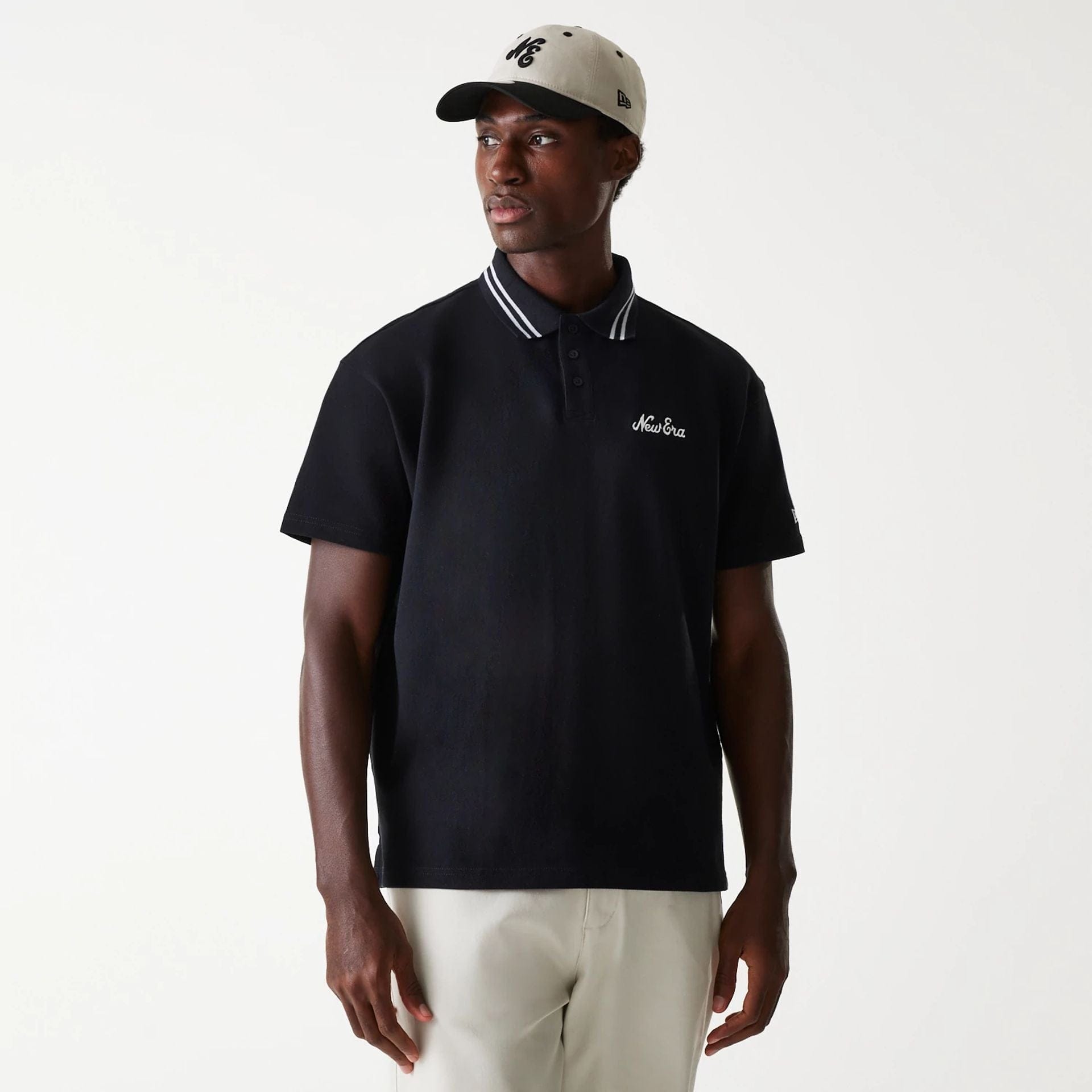 The Male model is wearing New Era Drop Shoulder Black Polo Shirt 1