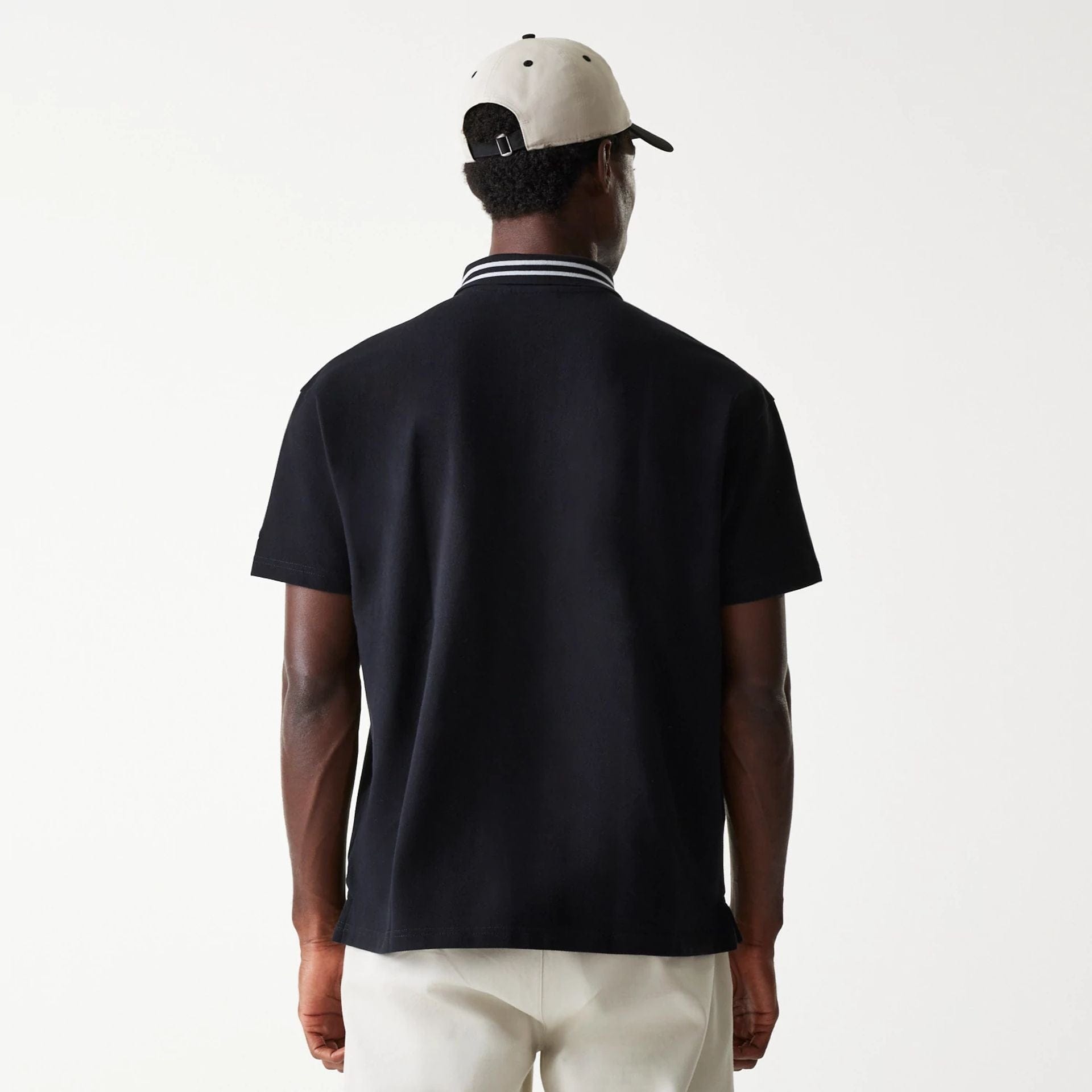 The Male model is wearing New Era Drop Shoulder Black Polo Shirt 2