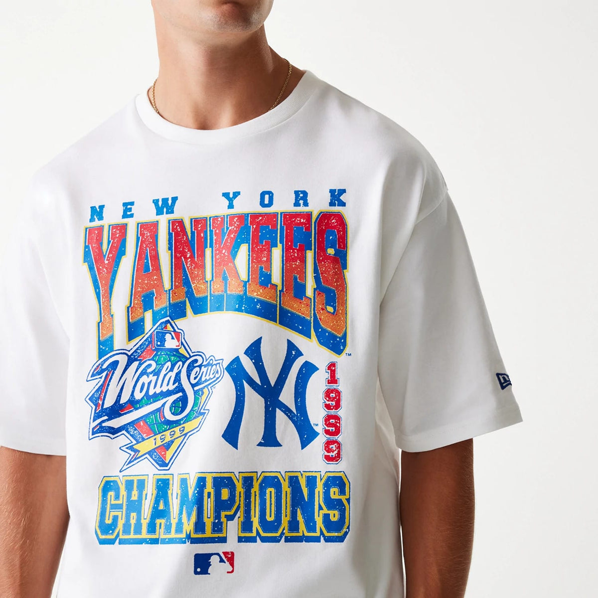 New Era New York Yankees MLB World Series 1999 White Oversized T-Shirt, front view showing the bold multicoloured Yankees and World Series graphics on the chest, with a raised New Era logo on the left sleeve.