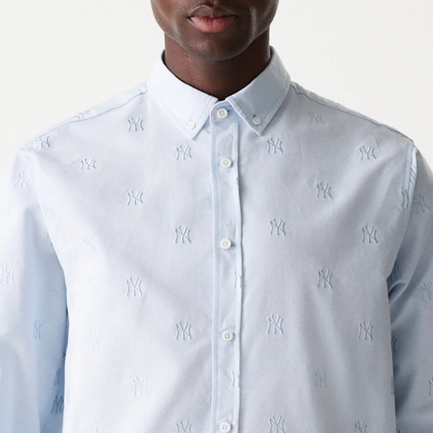 New Era New York Yankees MLB Monogram Pastel Blue Long Sleeve Shirt, front view showing the buttoned collar and embroidered NY logo pattern across the light blue fabric, with long sleeves and buttoned placket.