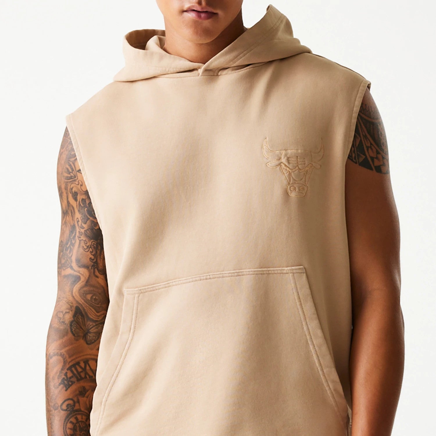 New Era Chicago Bulls NBA Washed Beige Sleeveless Hoodie, front view showing the relaxed fit with a large kangaroo pocket, a raised Chicago Bulls logo on the left chest, and a roomy hood, with sleeveless armholes highlighted.