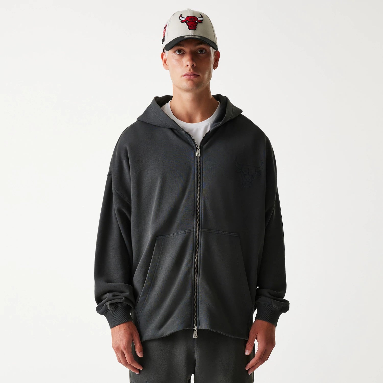 New Era Chicago Bulls NBA Washed Grey Full Zip Hoodie, front view showing the grey hoodie with a full zip closure, a debossed Bulls logo on the left chest, and a white cap with a raised Bulls logo on-model.