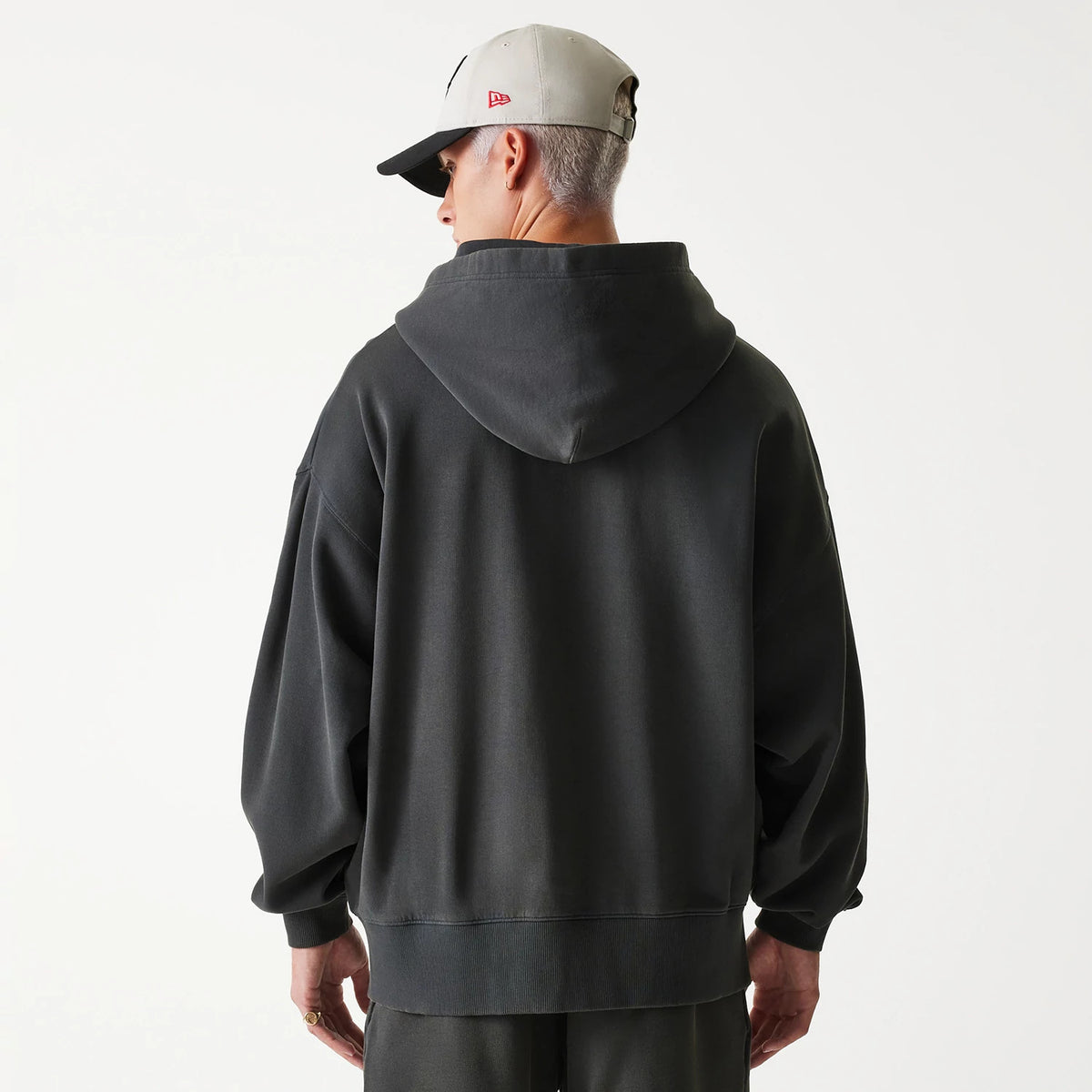 New Era Chicago Bulls NBA Washed Grey Full Zip Hoodie, on-model view showing the relaxed fit and hood from the back, paired with a grey cap featuring a raised red New Era logo on the side.
