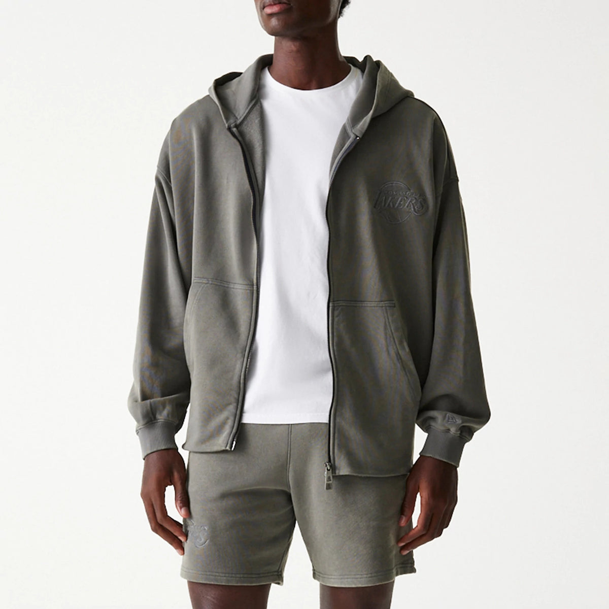 New Era LA Lakers NBA Washed Grey Full Zip Hoodie, on-model view showing the washed grey fabric with a raised LA Lakers logo on the left chest, a full zip closure down the centre, and a spacious hood resting on the shoulders.
