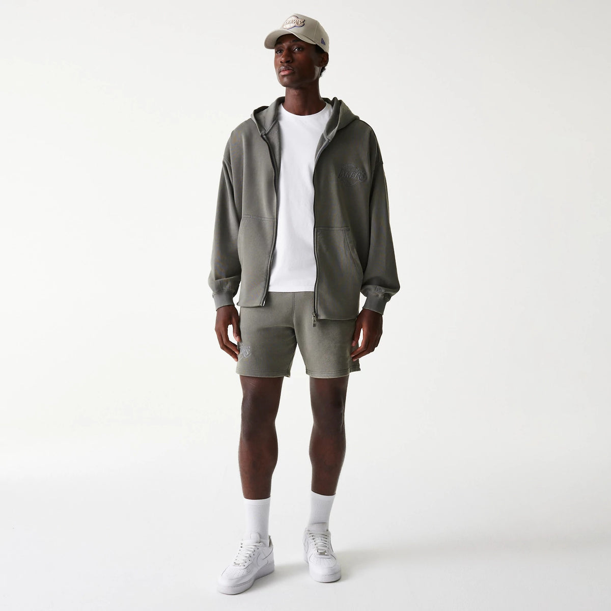 New Era LA Lakers NBA Washed Grey Full Zip Hoodie, on-model view showing the relaxed fit washed grey hoodie with a raised LA Lakers logo on the left chest, worn unzipped over a white t-shirt, paired with matching shorts and a cream cap.