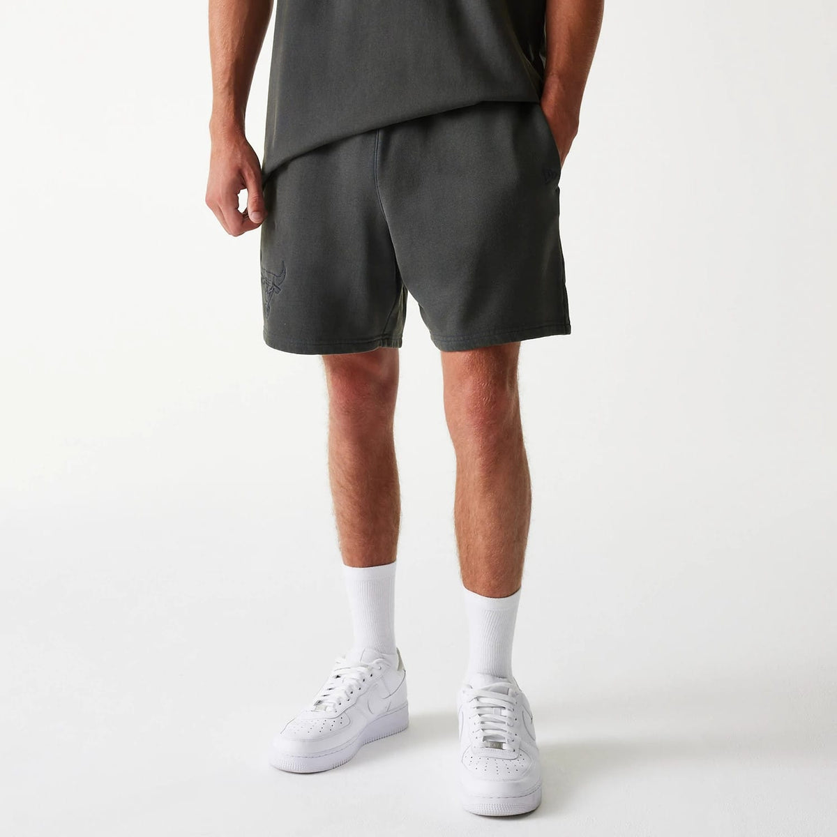 New Era Chicago Bulls NBA Washed Grey Shorts, front view showing the washed grey fabric with a raised Chicago Bulls logo on the left leg and a raised New Era logo on the right leg near the side seam.