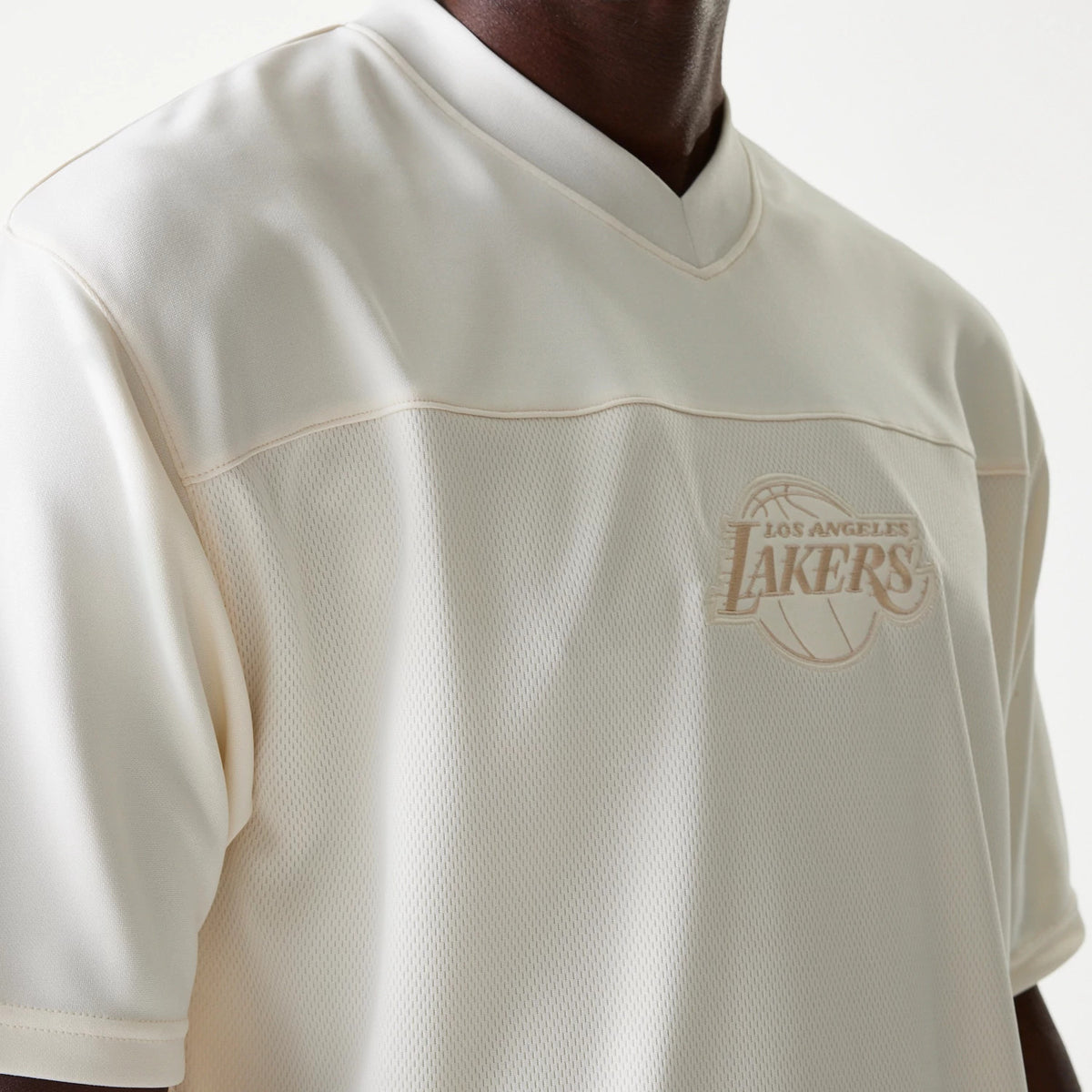 New Era LA Lakers NBA Tonal Open White Mesh Jersey, side view on a model highlighting the tonal embroidered LA Lakers logo on the chest, with soft mesh fabric and a smooth v-neck collar design.