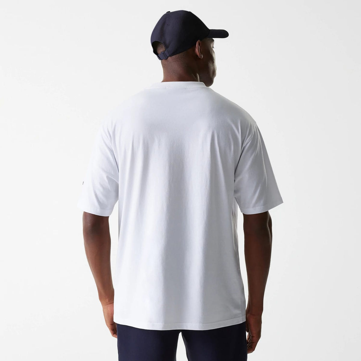 New Era New York Yankees MLB League Essential White Oversized T-Shirt, rear view showing the plain white back of the oversized t-shirt worn by a model, short sleeves extending slightly over the elbows and a straight lower hem.