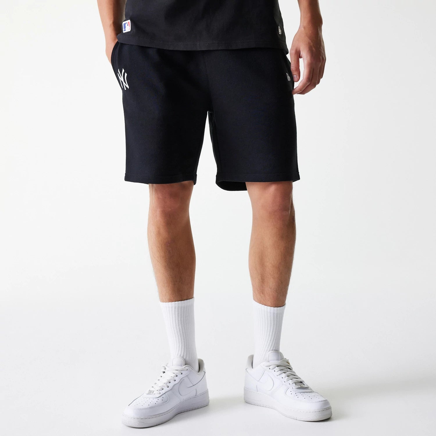 The Male model is wearing New York Yankees MLB League Essential Black Shorts 1
