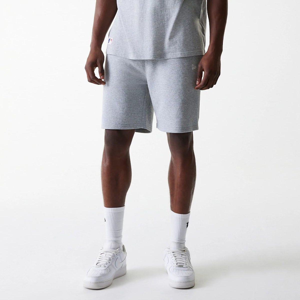 New Era New York Yankees MLB League Essential French Terry Grey Shorts, front view showing the soft grey fabric with a raised New Era logo on the lower front, waistband fitting snugly at the waist, and relaxed fit ending slightly above the knees.