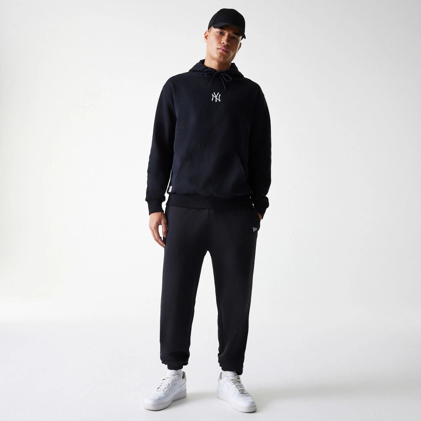 The Male model is wearing New York Yankees MLB League Essential Black Oversized Pullover Hoodie 7