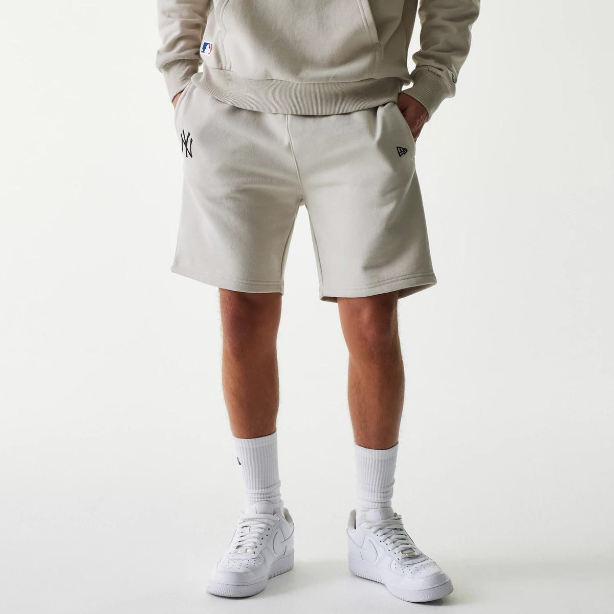 The Male model is wearing New York Yankees MLB League Essential Midi Cream Shorts 1