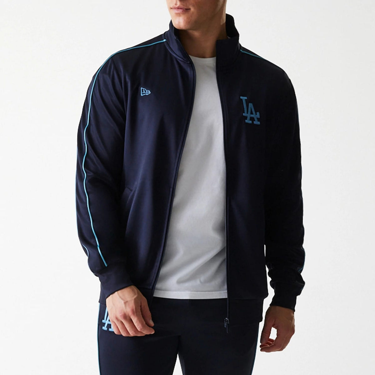New Era LA Dodgers MLB Navy Track Top, front view on a model wearing matching navy track pants and a white t-shirt, featuring the LA logo embroidered on the left chest and the New Era flag logo on the right chest.