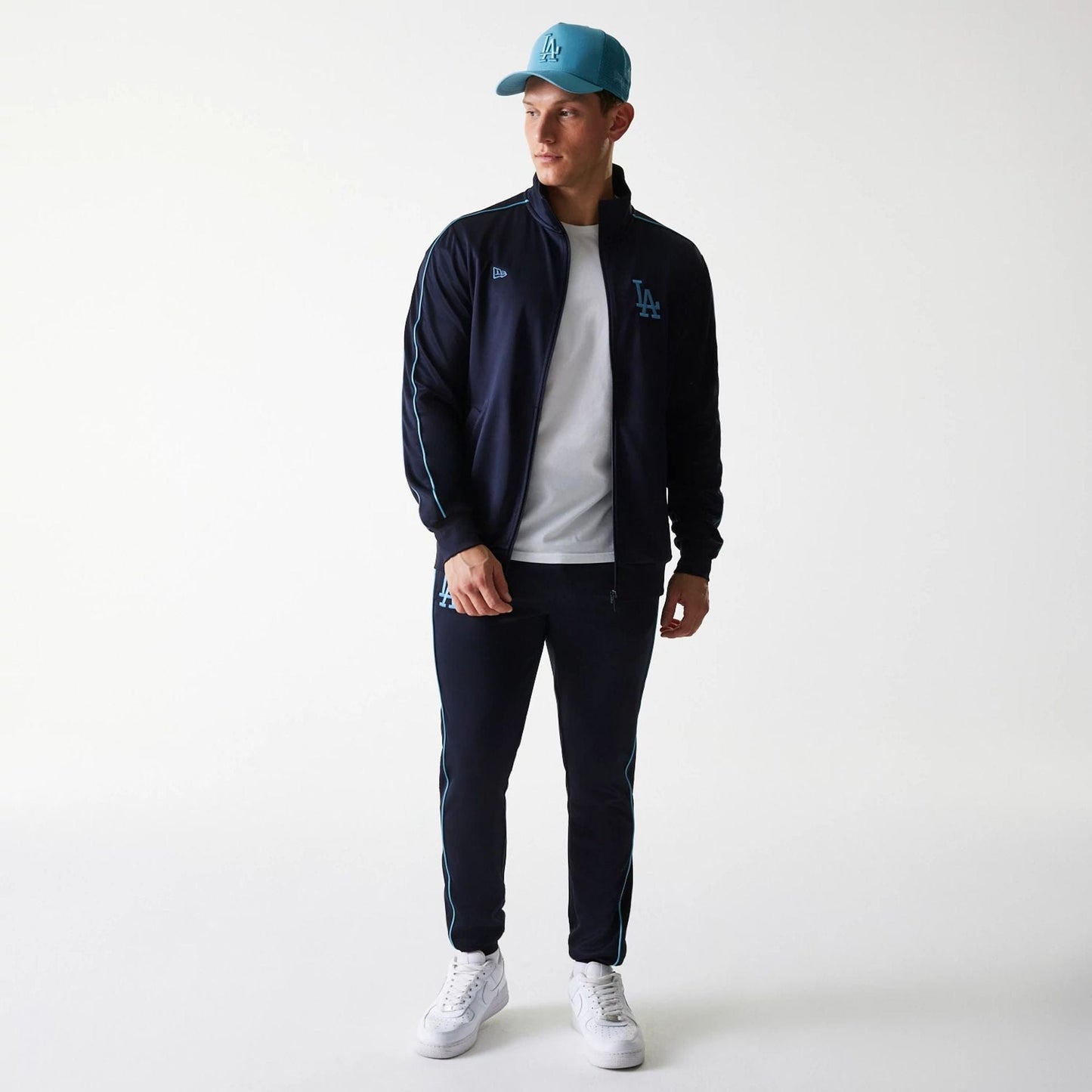 New Era LA Dodgers MLB Navy Track Top, on-model styled with matching navy track pants and a light blue cap, showing the LA logo embroidered in light blue on the left chest and the New Era flag logo on the right.